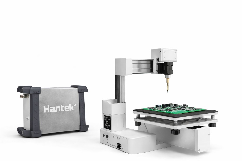 Hantek measurement hardware beside an automated robotic PCB probe station with a fine needle over a populated circuit board.